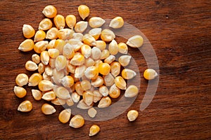 Macro Close up organic yellow corn seed or maize Zea mays cleaned on wooden top background photo