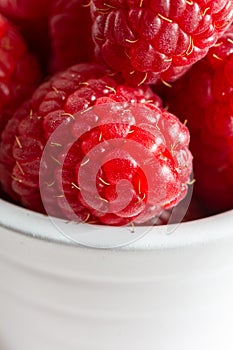 Macro close-up of red raspberries in white bowl