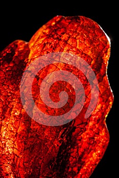 Macro close-up of rough raw amber stone isolated on black background