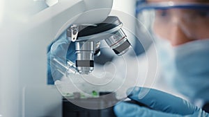 Macro Close Up Shot of Male Scientist in Medical Mask and Safety Glasses Mixing Green Chemical Liq