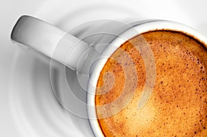 Macro close up studio shot of a half cup of espresso coffee