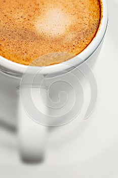 Macro close up studio shot of a half cup of espresso coffee