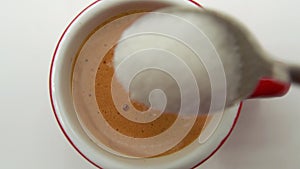 Macro.Close up of a teaspoon of sugar that dips gently into a cup of italian coffee.breakfast.coffee break.