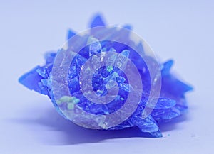 A macro close up view of copper sulphate crystal isolated on white