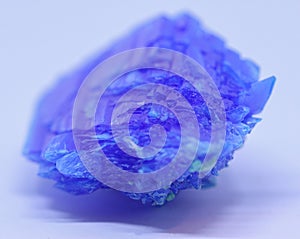 A macro close up view of copper sulphate crystal isolated on white