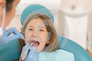 Macro close up of young child with open mouth at dentist. Teeth checkup at dentist& x27;s office. Dentist examining girls teeth in