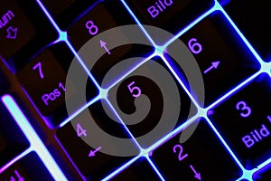 Macro closeup of blue illuminated function and number keys on numeric computer keypad