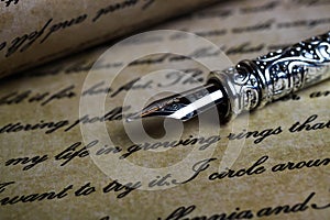 Macro closeup of retro ink pen, old vintage paper with handwritten text