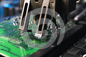 Macro closeup shot of surface-mount technology. SMD montage machine sticking together electric components such as