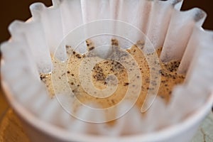 Macro of coffee with foam in paper filter during brewing process photo