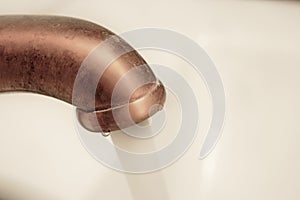 Macro of copper water tap with flow of water going out photo