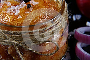 Macro delicious caviar, roe close up, pike caviar in a transparent jar, purple onion cut into rings on a black background, set