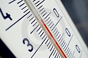 Macro detail of and old dusty outdoor thermometer in the retro design measuring high temperature of thirty five degrees of Celsius