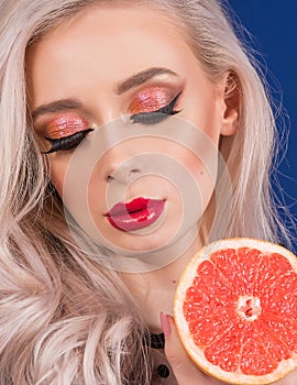 Macro Detail of Platinum Blonde Hair Woman, With Orange Glitter Make-up on her Eyes and Augmented Lips, Painted With Red Lipstick