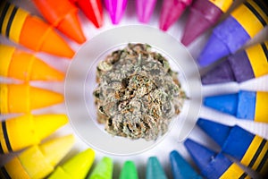 Macro detail of single cannabis nug surrounded by colorful crayon palette