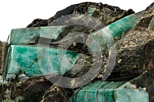 Macro emerald stone mineral in rock on white background