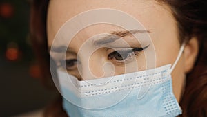 Macro eye view: Sad young woman in medical face mask looks away