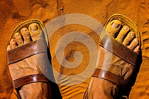 Macro of feet with sandals soiled with ocher and yellow sand in the roussillon ocher quarry