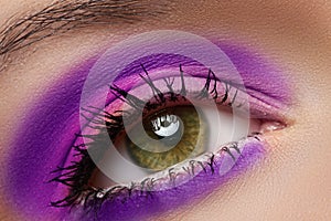 Macro of female eye with violet fashion make-up