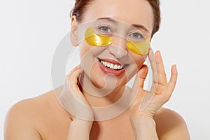 Macro female face. Beauty portrait of middle age woman with wrinkles and a gold patch under eye isolated on white background.