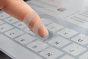 a macro of a finger typing text on the touch screen keyboard of mobile device