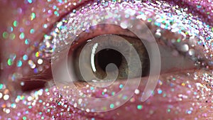 Macro green female eye with glitter eyeshadow, colorful sparks, crystals. Beauty background, fashion glamour makeup