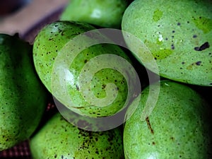 A macro of green raw mangoes