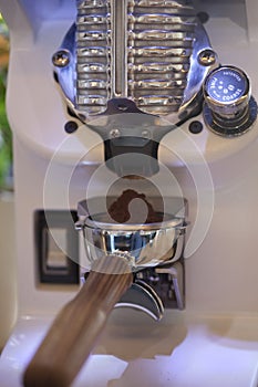 Macro of ground coffee in espresso holder, modern grinder