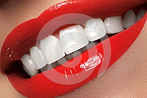 Macro happy woman's smile with healthy white teeth, bright red l