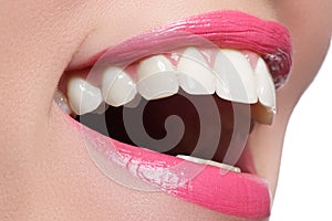 Macro happy woman`s smile with healthy white teeth, pink lips