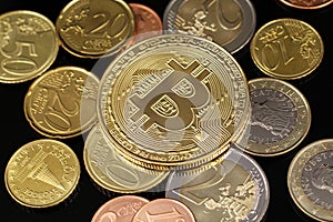 A close up image of Euro coins with a Bitcoin on a black background