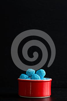 Macro Image of Blue Candies in a Red Bowl with Black Background