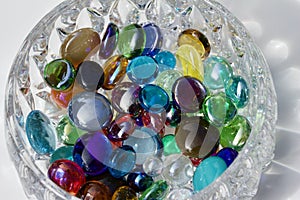 Macro image of colorful dragon tears glass stones surrounding a small crystal bowl