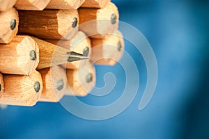 Macro image of graphite tip of a sharp ordinary wooden pencil as drawing and drafting tool, standing among other pencils