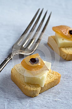 Macro Image of Mini Toast with Cheese, Caramelized Apple, Raisin and Antique Fork