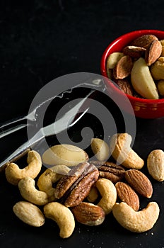 Macro Image of Mixed Nuts, Nutcracker Tool and Red Bowl