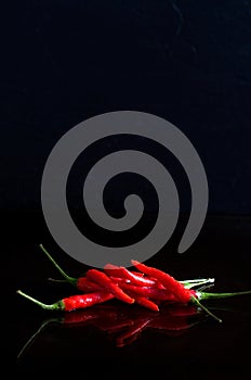 Macro Image of Red Hot Chilli Peppers on Black Background With Reflection
