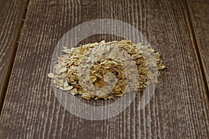 Macro image of rolled oats on a wooden background with copy space of the right half