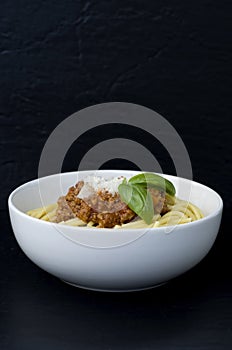 Macro Image of Spaghetti with Meat Sauce and Basil on Black Background