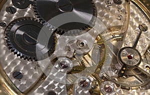 Macro image of a vintage watch mechanism showing the mechanical gearing and spring
