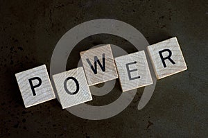 Macro Image of the Word Power in Wooden Blocks on Metal Background
