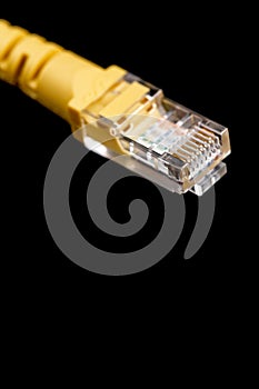 Macro image of yellow network plug over black background. Fiber optic.
