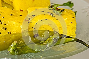 Macro of Indian Snacks Dhokla with fried chillies