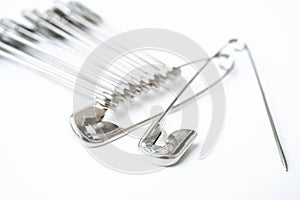 Macro metall safety pin for crafts, fashion, jewelry, hobby or household on white background.