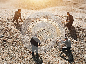 Macro miner figurines digging ground to uncover big shiny bitcoin