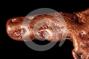 Macro mineral stone of a copper nugget on a microcline on a black background