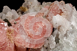 Macro of the mineral stone Rhodochrosite with fluorite on a black background