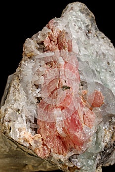 Macro of the mineral stone Rhodochrosite with fluorite on a black background