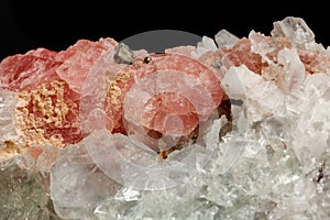 Macro of the mineral stone Rhodochrosite with fluorite on a black background