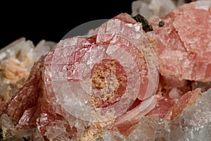 Macro of the mineral stone Rhodochrosite with fluorite on a black background